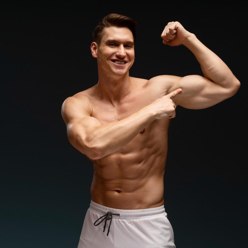 happy-athletic-model-demonstrating-biceps-while-po-2026-01-05-06-07-17-utc (1)